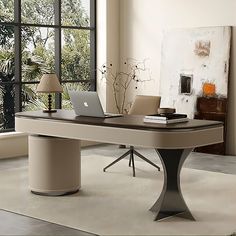 an office desk with a laptop on it in front of a large window overlooking the outdoors