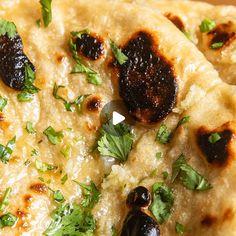 two flat breads with olives and parsley on top