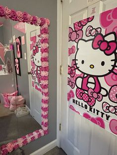 a hello kitty themed bathroom with pink flowers and roses on the door, and mirror