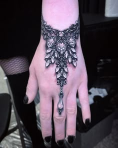 a woman's hand with a black and white tattoo on it