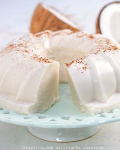 a cake on a plate with coconuts in the background