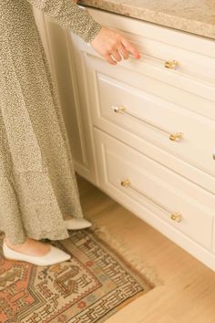 a woman standing in front of a kitchen counter