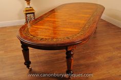 a wooden table sitting on top of a hard wood floor next to a lamp and wall