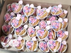 a box filled with heart shaped cookies covered in pink and blue sprinkles