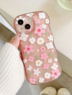 a person holding up a phone case with flowers on the front and back cover in pink