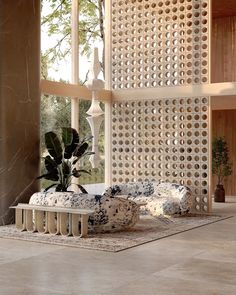 a living room filled with furniture next to a large window covered in white lattices