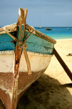 a boat sitting on top of a sandy beach