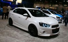 several white cars are on display at an auto show