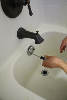 a person fixing a faucet in a sink