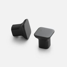 two black knobs on a white surface