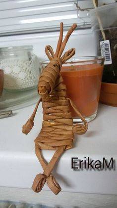 a close up of a paper mache figure on a counter near a cup of tea