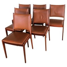 four brown leather dining chairs with matching footstools