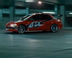 a red car with the number 24 painted on it's side in a parking garage