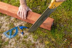 a person holding a large knife on top of a piece of wood