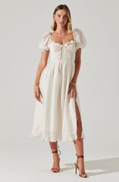 Puff sleeve midi dress Pleated bust with underwire Sweetheart neckline with ruffle and tie detail Left leg slit to above knee Concealed zipper at side seam Smocked back panel Fully lined, except sleeves Self: 81% Tencel, 19% Nylon / Lining: 100% Polyester Dry clean only Style #ACDR102144S Backless White Midi Dress, Neutral Long Sleeve Dress, Formal Wedding Guest Dress With Sleeves, Dresses With Bows On Shoulder, Italian Women’s Fashion, Winter Engagement Party Dress, Formal New Years Eve Dress, Smocked Midi Dress, Country Reception Dress