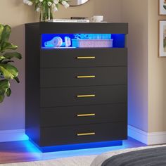 a black dresser with blue lights on the top and bottom drawers in front of it