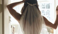 the back of a bride's dress, with her veil draped over her head