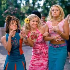 three women dressed in different outfits standing next to each other