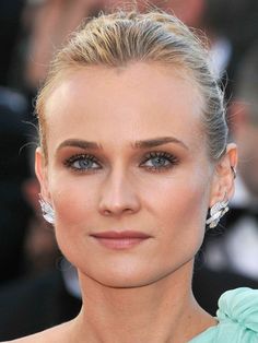 a woman with blonde hair and blue eyes in front of photographers on the red carpet