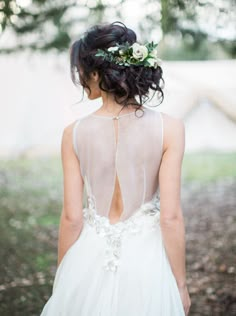 the back of a woman's wedding dress with flowers in her hair and an instagram