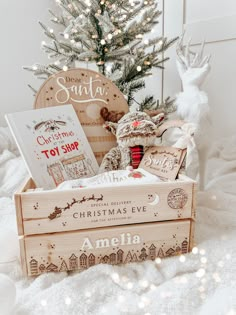 a wooden box with christmas items in front of a tree