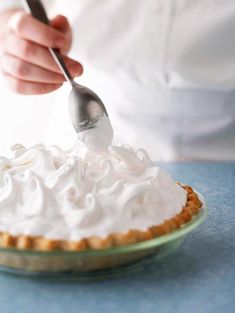 a person is spreading icing on a pie