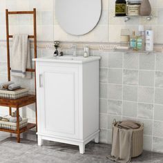 a white sink sitting under a mirror next to a wooden shelf with towels on it