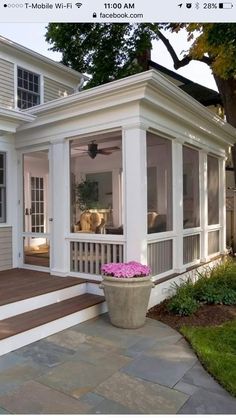 a white house with large windows and steps leading up to the front door