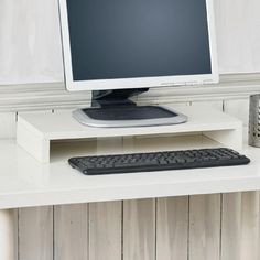 a computer monitor sitting on top of a white desk next to a keyboard and mouse