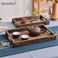 two wooden trays with tea cups on them