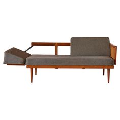 a couch that is sitting on top of a wooden frame and has a arm rest