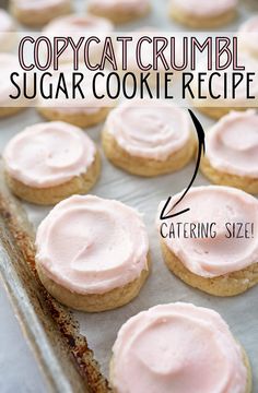 some cookies with pink icing are sitting on a baking sheet and the words copycat crumbl sugar cookie recipe