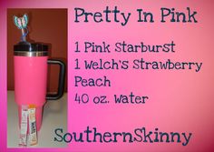 a pink starbucks cup sitting on top of a counter next to a sign that says pretty in pink