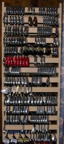 there is a rack with many different types of knives and spoons hanging on it