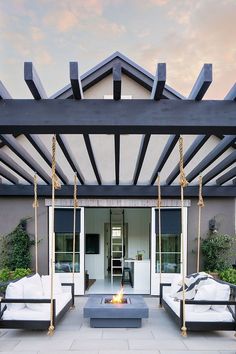 an outdoor living area with white couches and fire pit