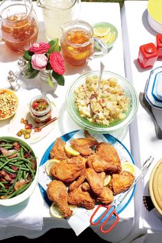 a table full of food and utensils on top of a white table cloth