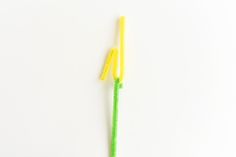 two yellow and green toothbrushes on a white surface, with one being used to brush the other's teeth