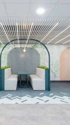 a room with two white couches and a green table in front of a patterned wall