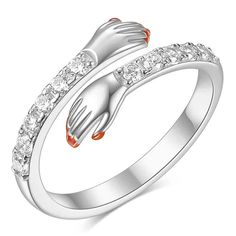 a white gold ring with an orange and white frog on it's side, surrounded by clear crystal stones