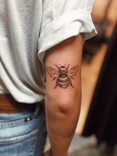 a woman with a bee tattoo on her arm