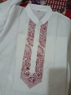 a white shirt with red designs on it