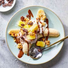 a banana split with nuts and ice cream on a plate next to a bowl of chocolate chips