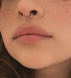 a woman's nose has a piercing on it and is looking at the camera