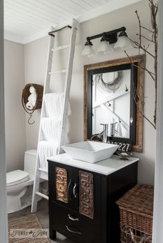 a bathroom with a sink, mirror and ladder in the wall next to the toilet