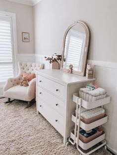 a white dresser sitting in a bedroom next to a window