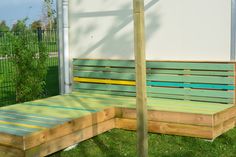 a wooden bench sitting on top of a green grass covered field next to a fence