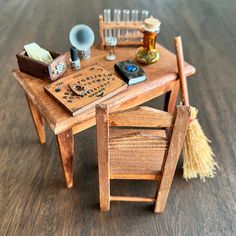 a miniature wooden table with brooms and other items on it