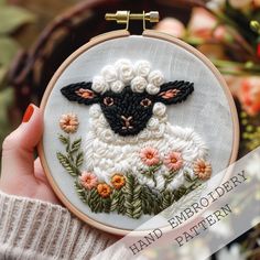 a hand embroidered sheep with flowers on it