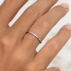 a woman's hand with a white diamond ring on her left hand and the word love written across it