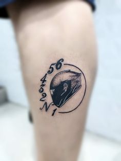 a tattoo on the leg of a person with a helmet and words written in black ink